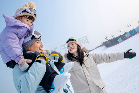 蓝天雪地摄影照片_滑雪场上快乐玩耍的三口之家