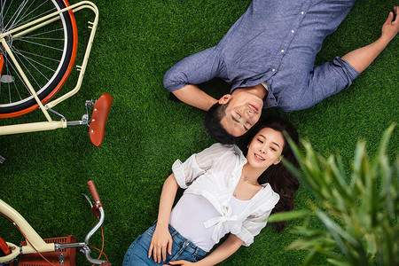 甜蜜图片摄影照片_甜蜜的青年伴侣躺在草地上