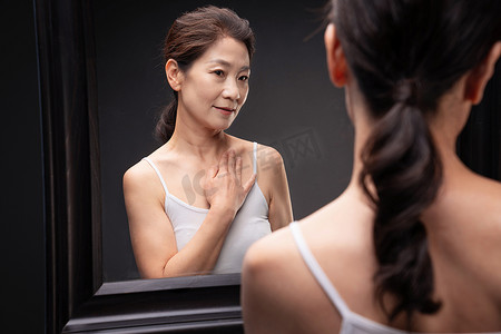 优雅的中年女性欣赏镜子中的自己