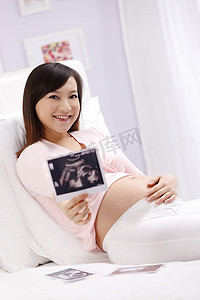 古人枕头摄影照片_孕妇拿着超声波照片