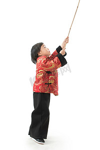 过新年的小男孩拿着竹竿玩耍