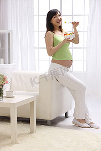 水果新鲜不新鲜摄影照片_孕妇吃水果沙拉
