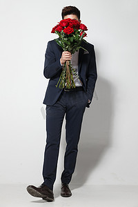 遮挡刘海摄影照片_青年男人拿着玫瑰花