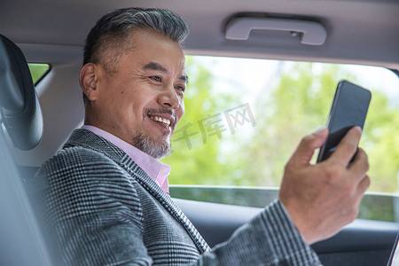 商务中老男士坐在汽车里进行视频电话