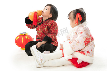 两个灯笼摄影照片_庆祝新年的两个小朋友坐在地上玩耍