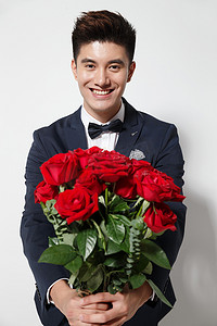 喜庆玫瑰花摄影照片_青年男人拿着玫瑰花