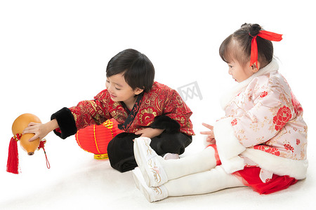 红色元宵节摄影照片_庆祝新年的两个小朋友坐在地上玩耍