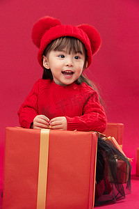 幸福的小女孩趴在礼物包装盒上