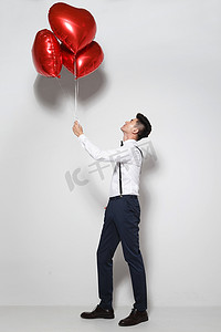 青年男人拿着心形气球