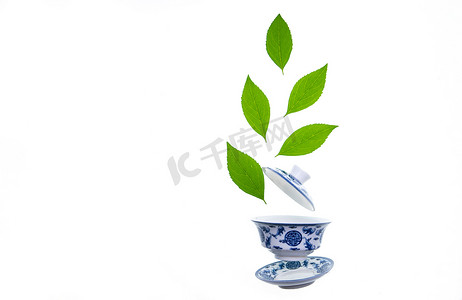 青花瓷摄影照片_绿色的茶叶和茶杯