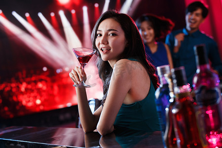 喝酒的美女摄影照片_青年女人在酒吧喝酒