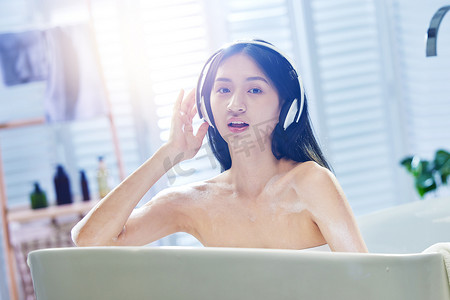 美女听音乐摄影照片_浴缸内听音乐的年轻女孩