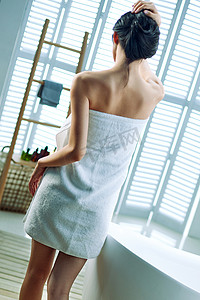背影窗户摄影照片_裹着浴巾的青年女人背影