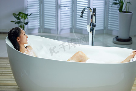 洗澡泡澡摄影照片_漂亮的年轻女人洗泡泡浴