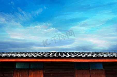 移动的飞机、多云蓝天和木屋屋顶