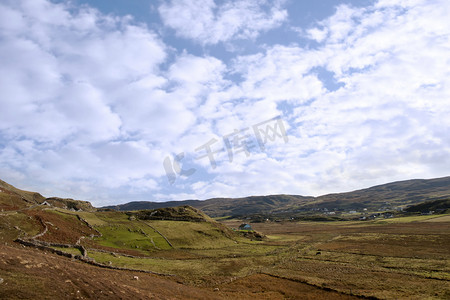 草地里的石头摄影照片_山丘上的田地