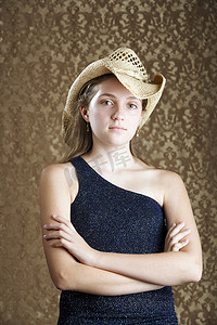 骑牛牧童摄影照片_牛仔帽的自信的年轻女孩