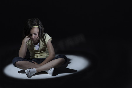 抑郁的孩子摄影照片_看起来悲伤的年轻女孩