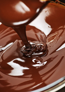 融化的巧克力滴摄影照片_融化的巧克力和勺子