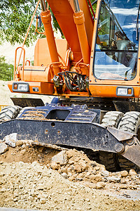挖沙摄影照片_工程中轮式装载机挖掘机挖沙并倒运