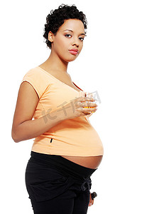 酗酒习惯摄影照片_孕妇在她的肚子旁边拿着一杯酒