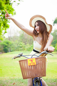 亚洲女子骑自行车并仰望天空