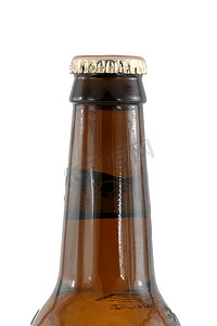 啤酒瓶啤酒盖摄影照片_带盖的隔离棕色啤酒瓶