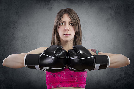 年轻漂亮的女人戴着拳击手套在生锈的 b 上锻炼