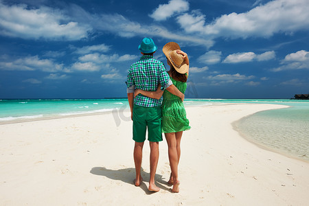 在马尔代夫的海滩上穿着绿色衣服的情侣