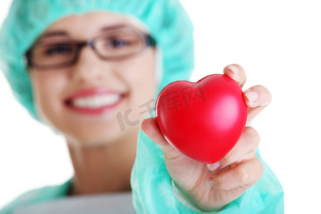拿着心脏的微笑的女性医生或护士