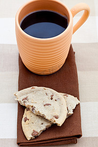 棕色餐巾纸上的巧克力曲奇饼和一杯咖啡
