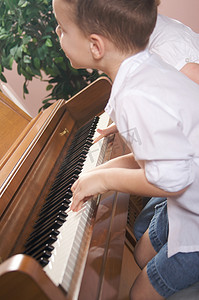 弹钢琴孩子摄影照片_弹钢琴的孩子