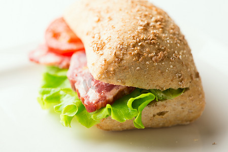 蕃茄摄影照片_与水平的蕃茄和芝麻菜的意大利腊肠三明治