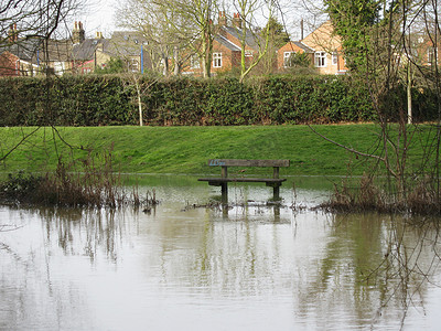 大雨动图摄影照片_洪水侵袭的河畔长凳