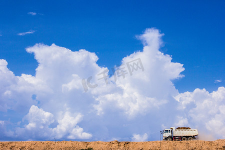 行驶在沙土上的卡车，以天空为背景。