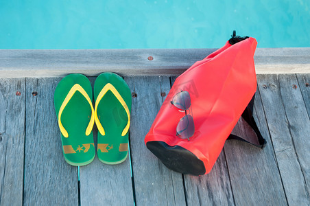 水袋气球摄影照片_海滩的东西，凉鞋太阳镜和海洋包