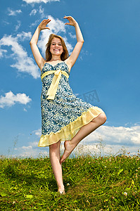在草地上跳舞的年轻女孩