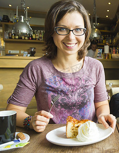 咖啡馆里微笑的女人吃着加奶油的苹果蛋糕甜点