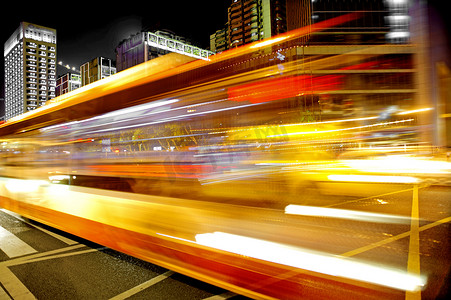 人生的道路摄影照片_市中心夜景中的高速和模糊公交车光轨