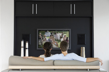 电视墙造型摄影照片_夫妇在客厅看电视电影的背影