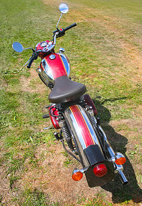 排气摄影照片_草地上的红色摩托车