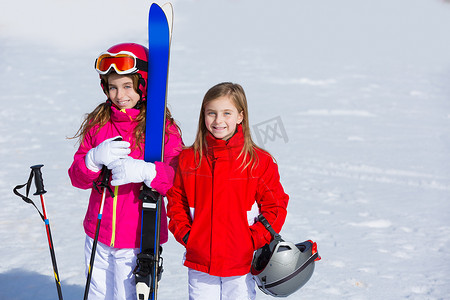 滑雪女孩子摄影照片_冬雪中的小女孩姐妹带着滑雪设备