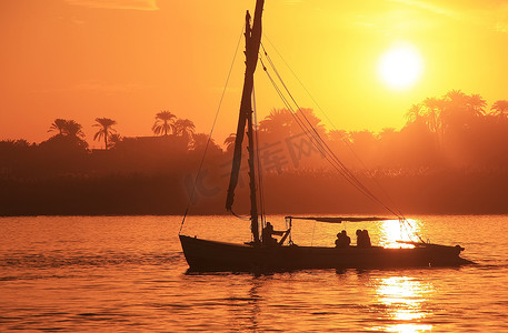 尼罗河摄影照片_Felucca 船在日落时在尼罗河上航行，卢克索