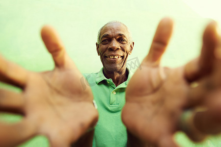 人张开手摄影照片_非洲老人张开手和双臂，拥抱着相机