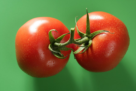 餐食图片摄影照片_红色番茄在绿色背景下的宏观拍摄