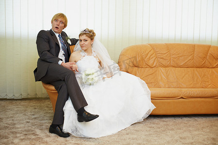 未婚夫摄影照片_有趣的新郎和新娘坐在扶手椅上