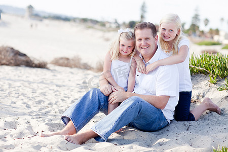 女儿们摄影照片_英俊的爸爸和他可爱的女儿们在海滩上
