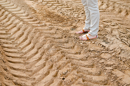 女人的腿站在采石场的沙车轨道上