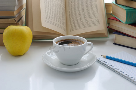 咖啡纸摄影照片_书桌上的一杯咖啡和一个苹果