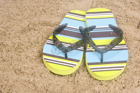 鞋子夏季摄影照片_绿色夏季拖鞋躺在沙滩上